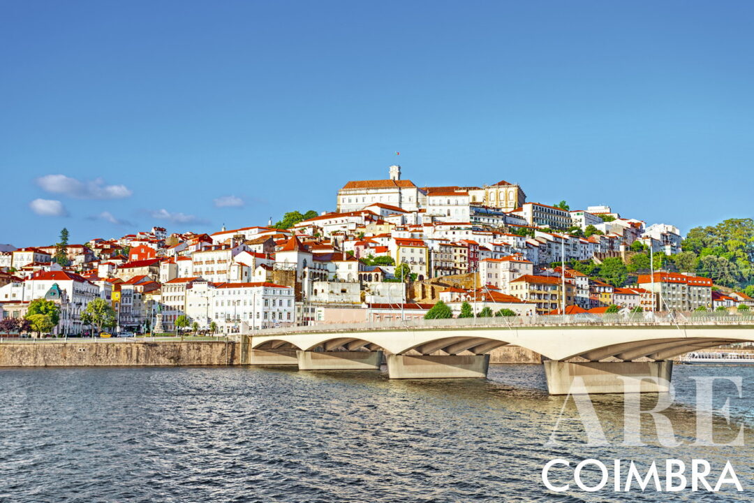 Vista de la ciudad de Coimbra desde la orilla sur del río Mondego, con el puente de Santa Clara. En lo alto de la ciudad podemos ver la torre del reloj y los edificios de la Universidad de Coimbra. Fundada en 1290, la Universidad de Coimbra es la universidad más antigua de Portugal y una de las más antiguas del mundo.